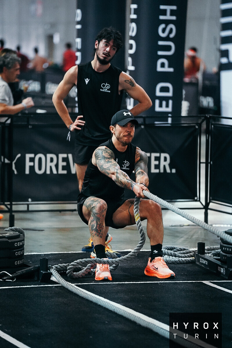 Atleta AB Lab esegue sled pull durante una gara Hyrox